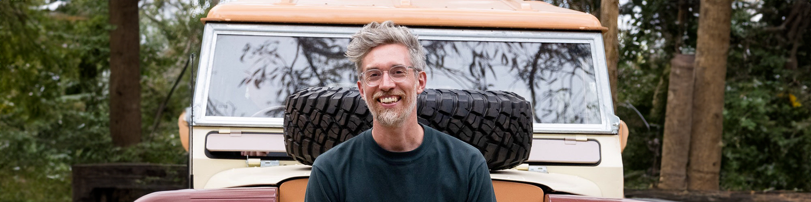 Man smiling in front of a custom built Land Cruiser