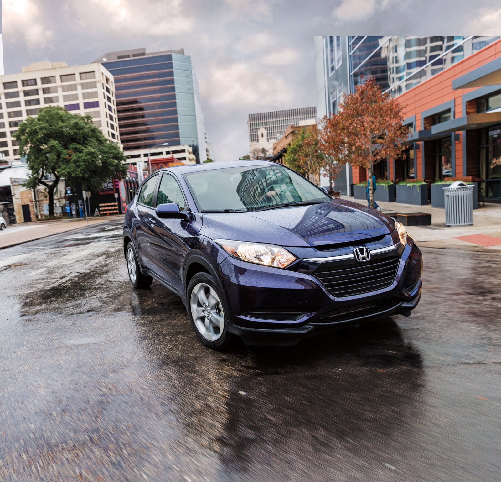 Passenger sedan cornering on a wet city street